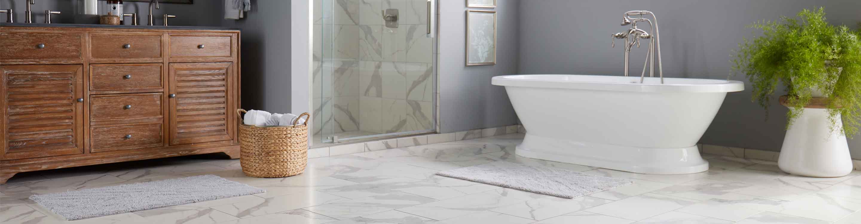 white bathroom with tile flooring, white tub, plant next to tub